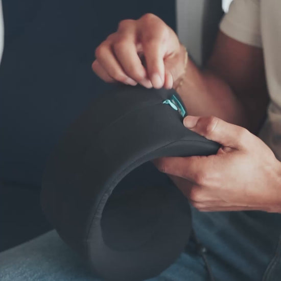 Unzipping back zipper on Evolution X pillow to reveal adjustable strap that alters the circumference of the pillow